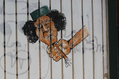 Un grafiti retrata a una mano agarrando la cabeza del fallecido dictador libio Muamar el Gadafi.