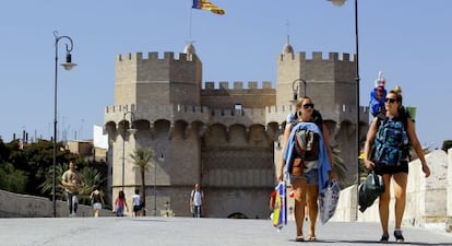 Dos turistas cruzan el puente de Serranos, ya liberado del tr&aacute;fico.