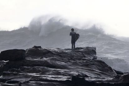 Un surfista contempla las olas provocadas por un temporal en Avoca Beach, Sidney (Australia).