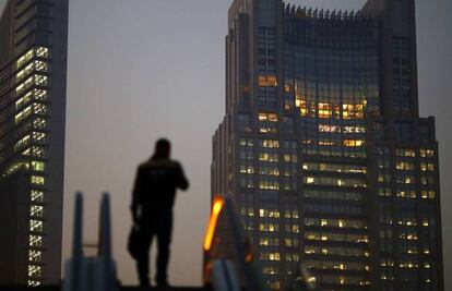 Un hombre sube una escalera mecánica en el distrito financiero de Shanghái, China.