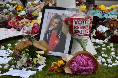 Flores y tributos, incluyendo un ramo de flores que piden el voto de permanecer en la Unión Europea, se amontonan en memoria de una fotografía de la diputada asesinada Jo Cox en Parliament Square, Londres, el 18 de junio de 2016.