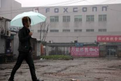 Un hombre camina junto al complejo empresarial Foxconn, en Kunshan, en la provincia china de Jiangsu. EFE/Archivo