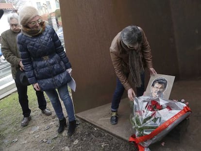 La viuda de Joseba Pagazaurtundua, Estíbaliz Garmendia, coloca una flores ante la escultura 'La casa de Joseba', en presencia de Maite Pagazaurtundua.