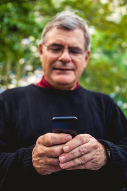 Un hombre consulta su tel&eacute;fono inteligente. 