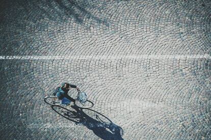 Una persona circula en bicicleta por la calle.
