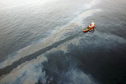 Un barco cruza parte de la mancha causada por la fuga en la plataforma Casablanca.