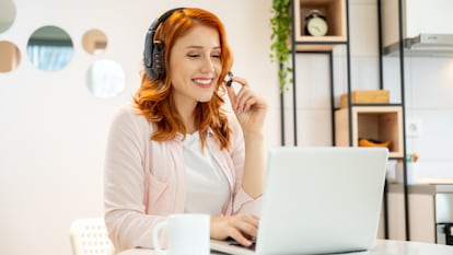 Mujer trabajando con unos auriculares con micrófono puestos.