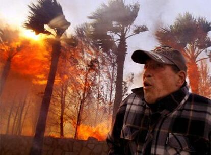 Un vecino intenta acceder a su casa incendiada en el municipio alicantino de La Nucía.