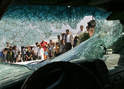 Un agente de la policía palestina observa el impacto de uno de los disparos en el coche oficial.