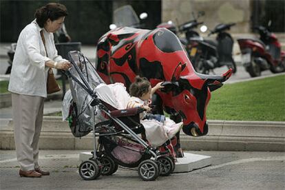 Una niña acaricia a una de las vacas de la avenida de Pau Casals de Barcelona.