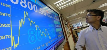 Un hombre consulta una pantalla informativa con los datos de la bolsa en Hong Kong (China).
