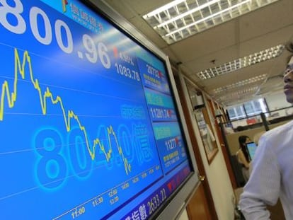 Un hombre consulta una pantalla informativa con los datos de la bolsa en Hong Kong (China). 