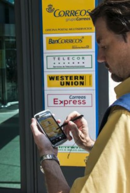 Un empleado de Correos usa una de las nuevas PDA.