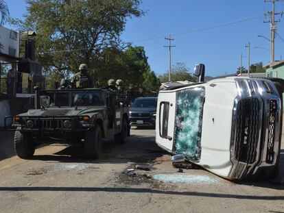 Soldados transitan frente a un vehículo baleado en Jesús María, Sinaloa, en enero de 2023.