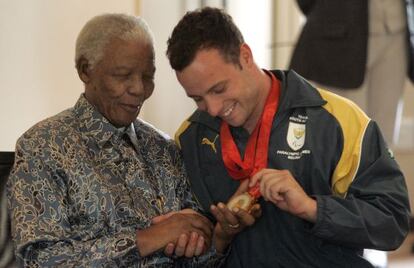 Pistorius muestra a Mandela las medallas de oro que logró en los Paralímpicos de Pekín, en 2008.