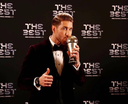 Curioso fue también el traje elegido por el capitán del Real Madrid para la gala de entrega de premios del FifProWorldXI, unos premios que la FIFA y FIFPro, entrega a los 11 futbolistas más destacados del mundo por demarcación. En la imagen se puede ver a Ramos besando el galardón mientras luce un traje de terciopelo granate.