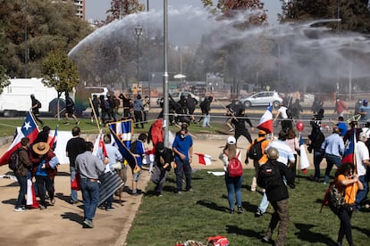 Un grupo de manifestantes contrarios a la redacción de la nueva Constitución de Chile se enfrenta a un grupo de izquierdas