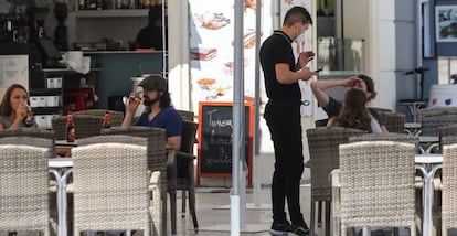 Un camarero atiende a los clientes en la terraza de un bar, en Madrid.