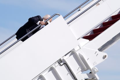 El presidente Joe Biden se agarra a una barandilla tras tropezar mientras embarcaba en el Air Force One en Maryland, el 19 de marzo de 2021. En el equipo de Biden restaron importancia a los tropiezos. El presidente ”está bien al cien por cien”, dijo a los periodistas Karine Jean-Pierre, subsecretaria de prensa de la Casa Blanca.