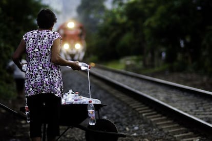 Apostadas en fila junto a las vías del tren, estas mujeres reparten comida y agua a los cientos de migrantes que diariamente cruzan el territorio mexicano en busca del sueño americano. Les dan (lanzan) botellas de plástico atadas con una cuerda de rafia, y bolsas con panes de arroz y frijoles. Este será posiblemente el poco alimento que los que van montados en el tren prueben en varios días. Doña Leonila, fundadora de las Patronas, aguarda el paso del convoy mientras sostiene las botellas de agua.