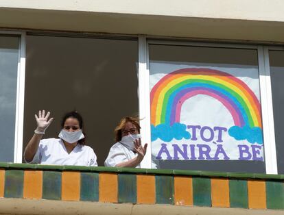 Dos cuidadoras saludan desde una ventana de la residencia geriátrica Casa Benéfica de El Masnou (Barcelona), este martes, cuando se cumple el décimo día del estado de alarma decretado por el Gobierno por la pandemia de coronavirus.