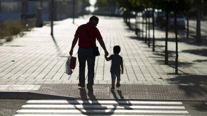 Un hombre lleva a su hijo al colegio, en una fotografía de archivo.