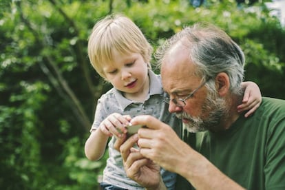 Un niño juega con su abuelo en el móvil.