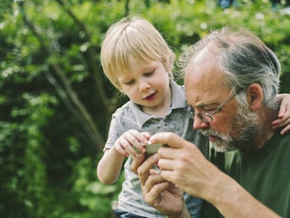 Un niño juega con su abuelo en el móvil.