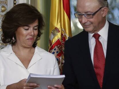 La vicepresidenta del Gobierno, Soraya Sáenz de Santamaría, y el ministro de Hacienda, Cristóbal Montoro, sostienen el informe sobre financiación autonómica.