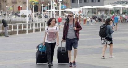 Turistas cruzan una avenida de Gijón, en una fotografía de archivo.