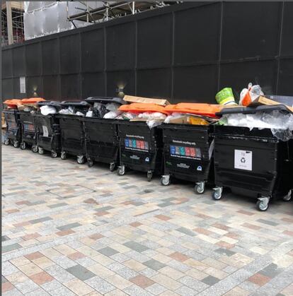 Los vecinos de la “puerta de los pobres” llevan una cuenta de Instagram llamada @real_embassygardens donde revelan “el lado oscuro” del edificio. En la imagen, los cubos rebosantes de basura que nadie vacía que tienen en su entrada.