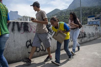 Moradores da Rocinha se protegem nesta sexta-feira em que os tiroteios entre facções rivais piorou notoriamente