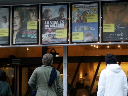 Dos personas contemplan la cartelera de un cine madrileño.