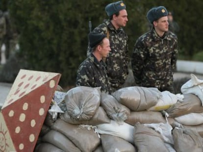 Soldados ucranianos se protegem atrás de sacos de terra na base de Belbek, próximo a Sebastopol.