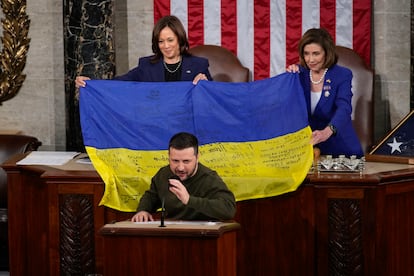 Kamala Harris y la presidenta de la Cámara de Representantes, Nancy Pelosi, reciben una bandera ucraniana mientras el presidente ucraniano Volodymyr Zelenskyy habla en el Capitolio en Washington, el 21 de diciembre de 2022. 