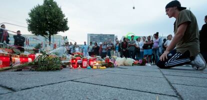 Ciudadanos ponen flores y velas en el lugar del tiroteo. 