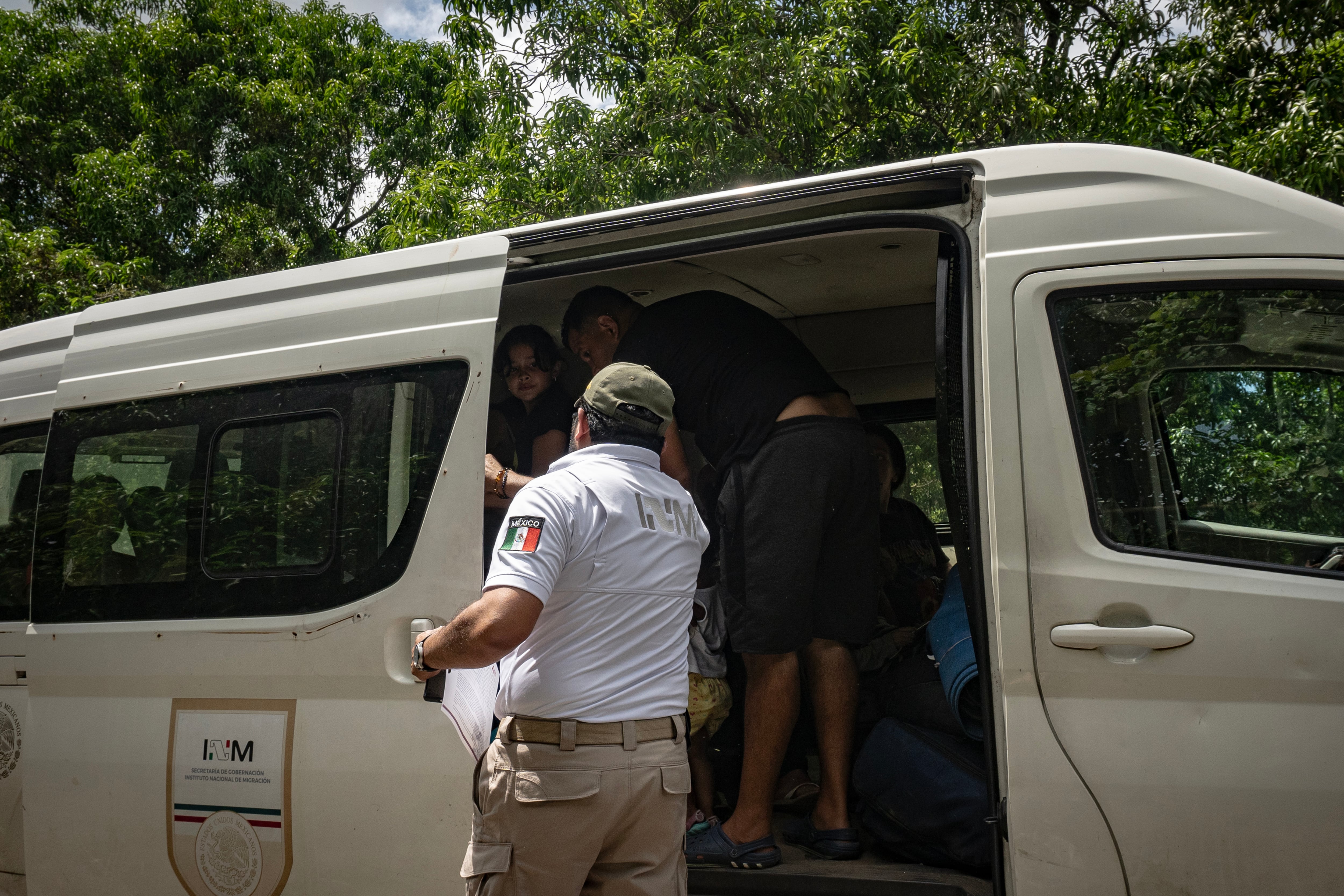 Un elemento del Instituto Nacional de Migración sube a personas de diversas nacionalidades a una camioneta de Gobernación para trasladarlos a la Estación Migratoria Siglo XXI.