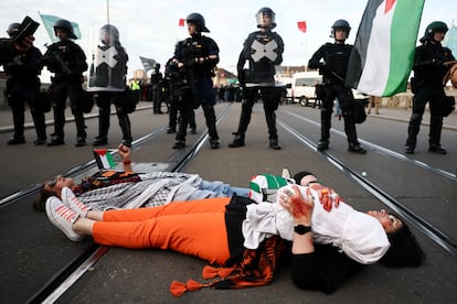 Varios manifestantes protestan a favor de Palestina en un puente sobre el río Rin, en Basilea (Suiza), este sábado antes del festival.