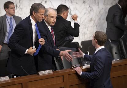 Zuckerberg saluda a los senadores John Thune (i) y Chuck Grassley (d) tras la delcaración del fundador de Facebook en el Senado. 