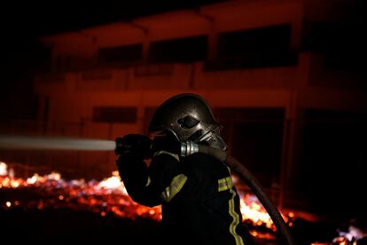 Els bombers lluitant dimarts a la matinada contra les flames a l'Àtica al mateix temps que esclataven altres incendis en altres regions gregues. A la imatge, un bomber al poble de Mati, prop d'Atenes.