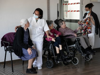 Dos trabajadoras conversan con las usuarias de la residencia geriátrica Sant Pere les Fonts de Terrassa con la mascarilla puesta.