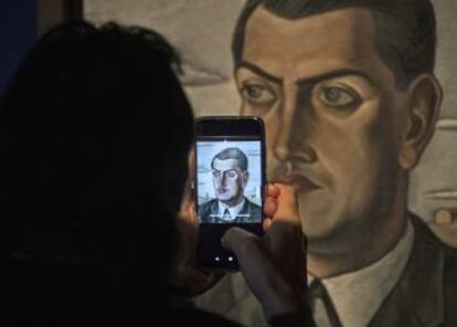 Un visitant treu una foto de la pintura 'Retrat de Luis Buñuel' (1924), de Salvador Dalí, dilluns a Moscou.