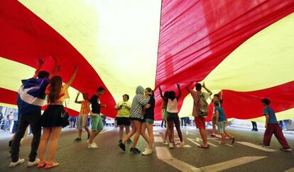 Los manifestantes portan una enorme 'senyera' en la manifestación del 9 d'Octubre en Valencia.