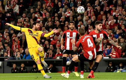 El delantero argentino del FC Barcelona Leo Messi, de amarillo, remata junto a tres jugadores del Athletic Club de Bilbao.