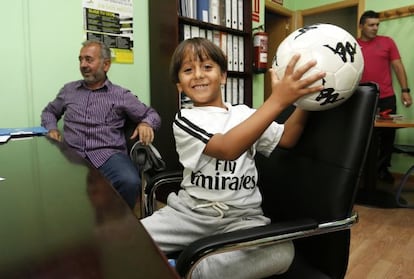 Zaid, junto a su padre, Osama Abdul Mohsen (a la izquierda), juega con un balón en las oficinas de Cenafe, en Getafe.