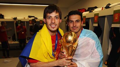 Silva, con la bandera de Las Palmas, y Pedro con la de Tenerife, sostienen la Copa del Mundo conseguida por España en Sudáfrica 2010.