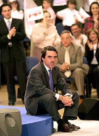 Aznar se sienta en el suelo tras ser interrumpido en varias ocasiones con gritos de "No a la guerra".