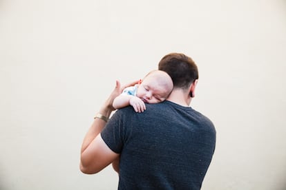 Un padre coge en brazos a su bebé.