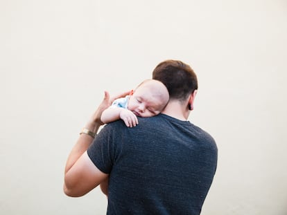 Un padre coge en brazos a su bebé.