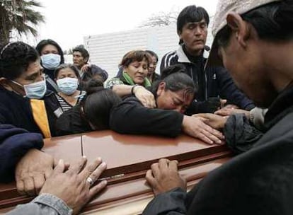 Una familia de Pisco llora sobre el ataúd de un pariente muerto en el terremoto.